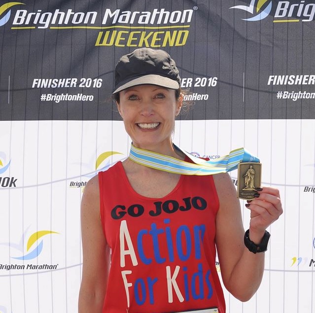 Runner holds up her medal at Brighton Marathon