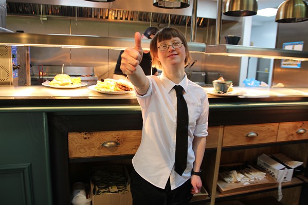 Krystyna at Wetherspoons Smiling young woman with learning disabilities working as a waitress giving thumbs up
