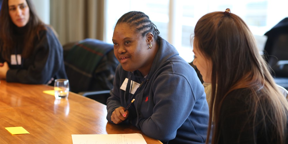 Young woman with Down syndrome sitting at a conference table with others