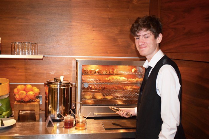 Adam in Citadines Young man in hotel uniform standing at a hotel breakfast counter