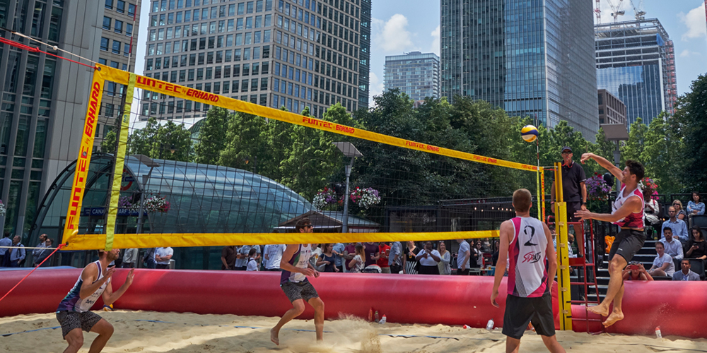 Beach volleyball with buildings and trees in the background
