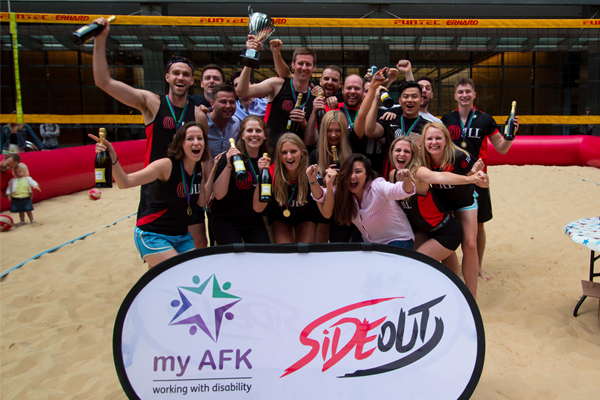 Beach volleyball championship team celebrate with a trophy