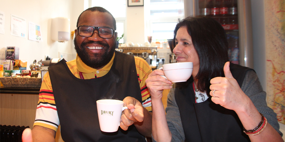 Man and woman drinking tea giving thumbs up
