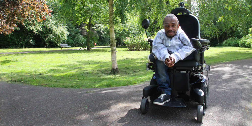 Man in a powered wheelchair in a park