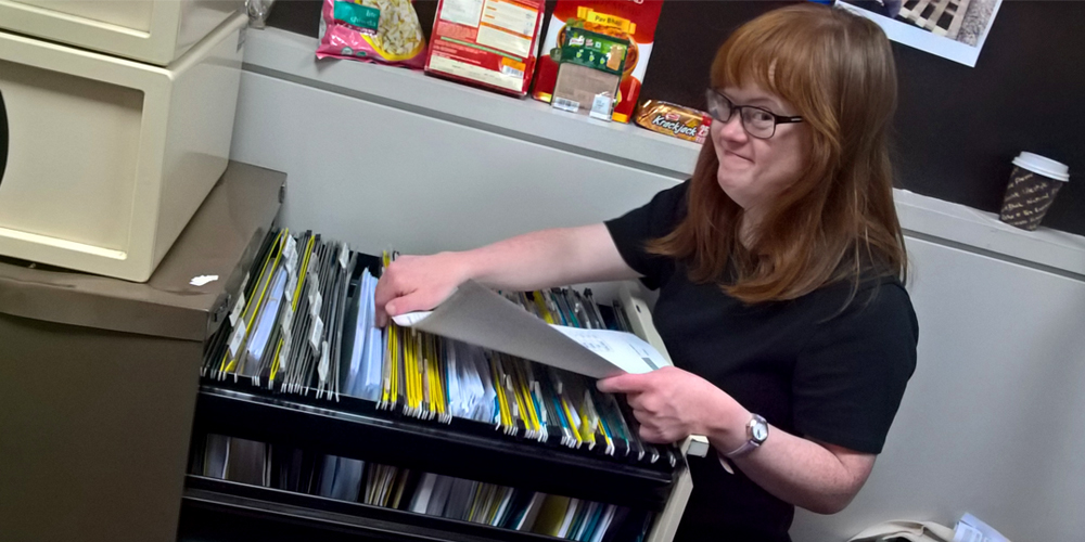 Young woman with Down syndrome filing paperwork