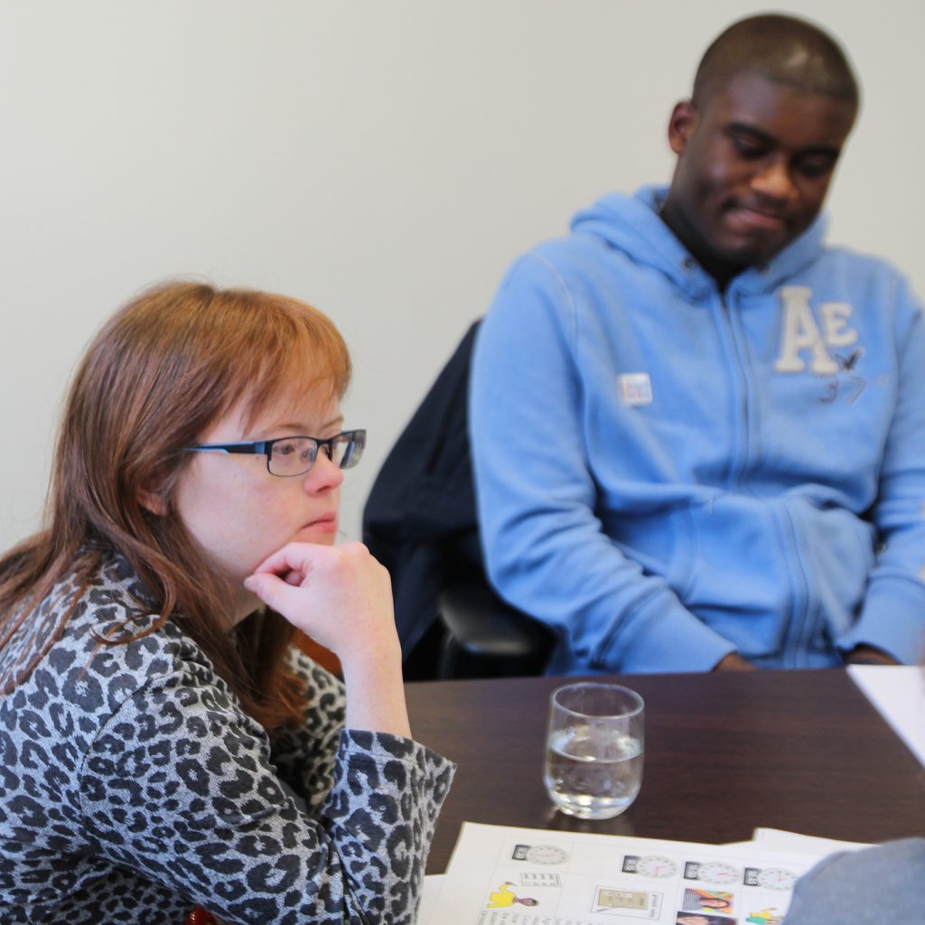 Young woman and young man at a conference table in a meeting