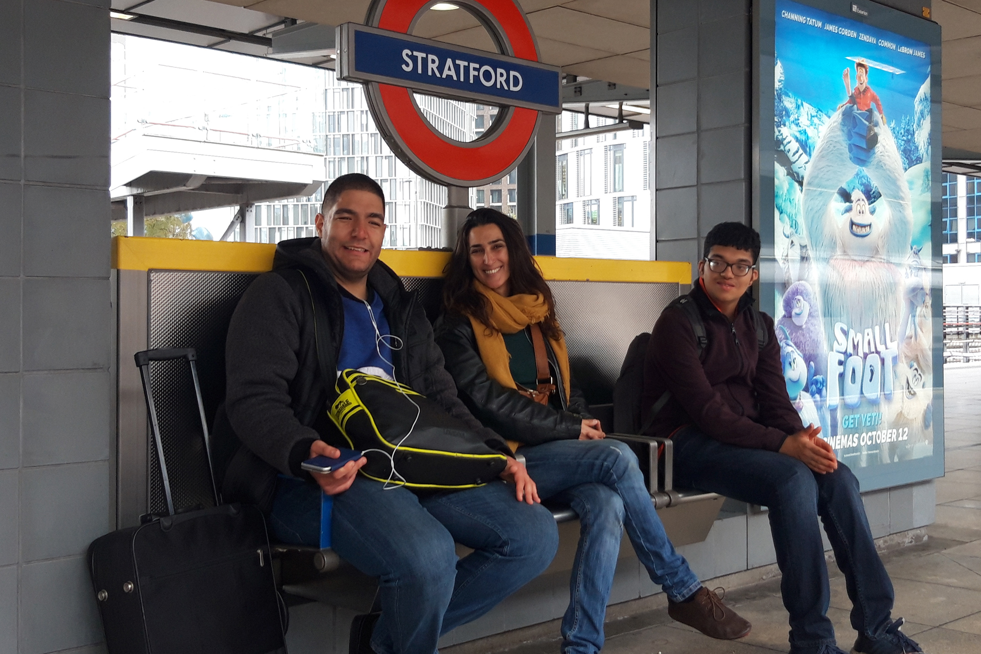 Group sitting on the train platform at Stratford