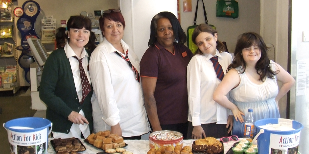 5 women at a bake sale table with collection buckets