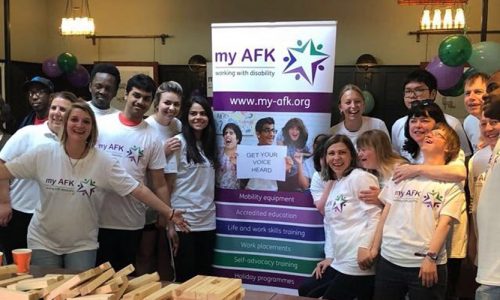 Group of people with my AFK tshirts in a room with a banner behind them