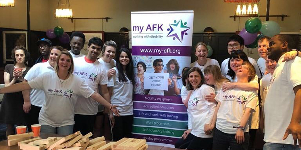 Group of people with my AFK tshirts in a room with a banner behind them