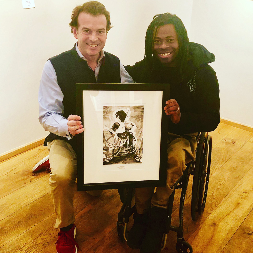 Artist Jeremy Houghton with Ade Adepitan holding the print of Adepitan.