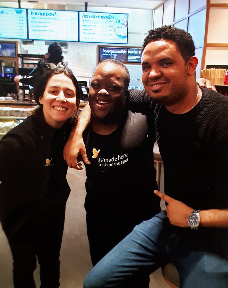 A young man with Down Syndrome with his managers in an Itsu sushi resturant