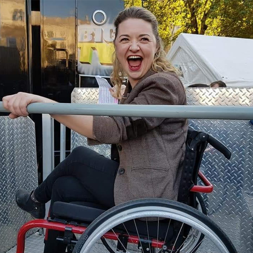 pops-3 Dr Hannah Barham-Brown smiling in her red wheelchair