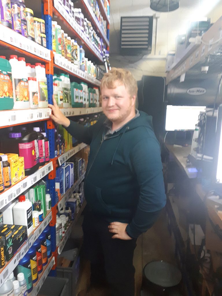 Conor hydroponics Young man stocking shelves at work