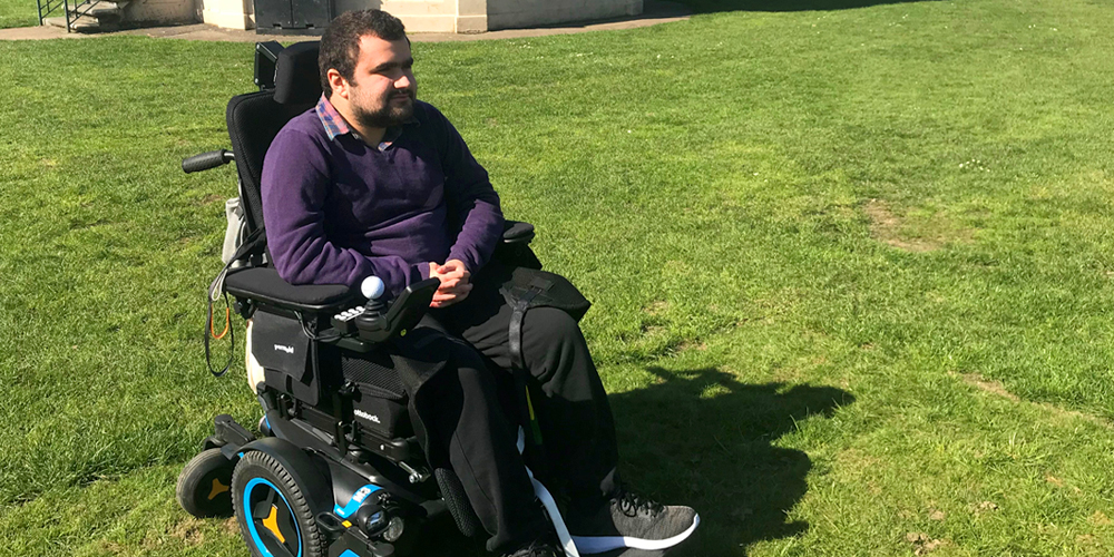 man sitting in powerchair on grass