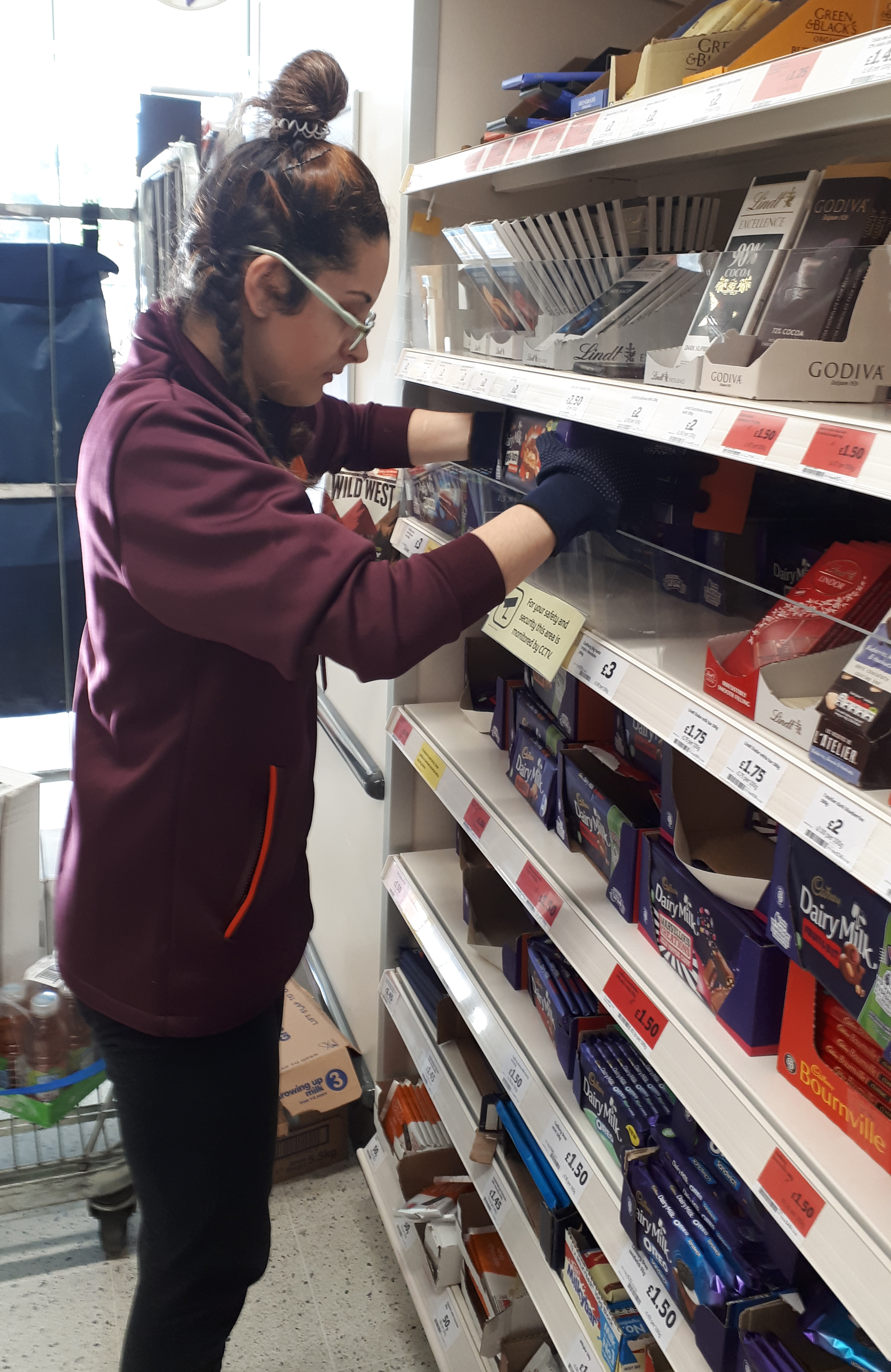 Young woman stocking shelves at Sainsbury's