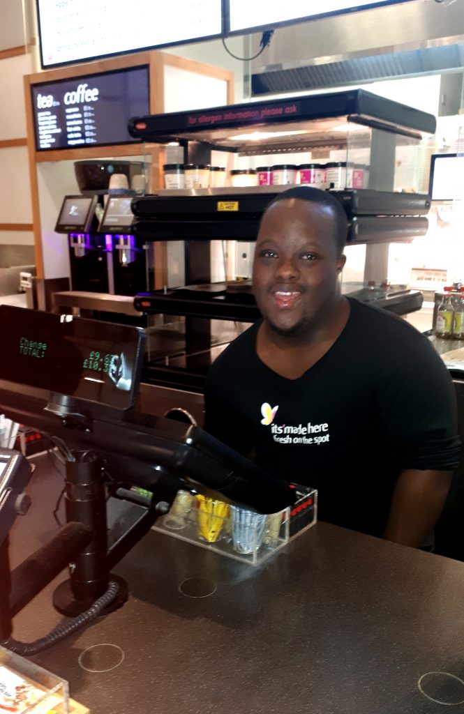 young man at work behind the tills at itsu