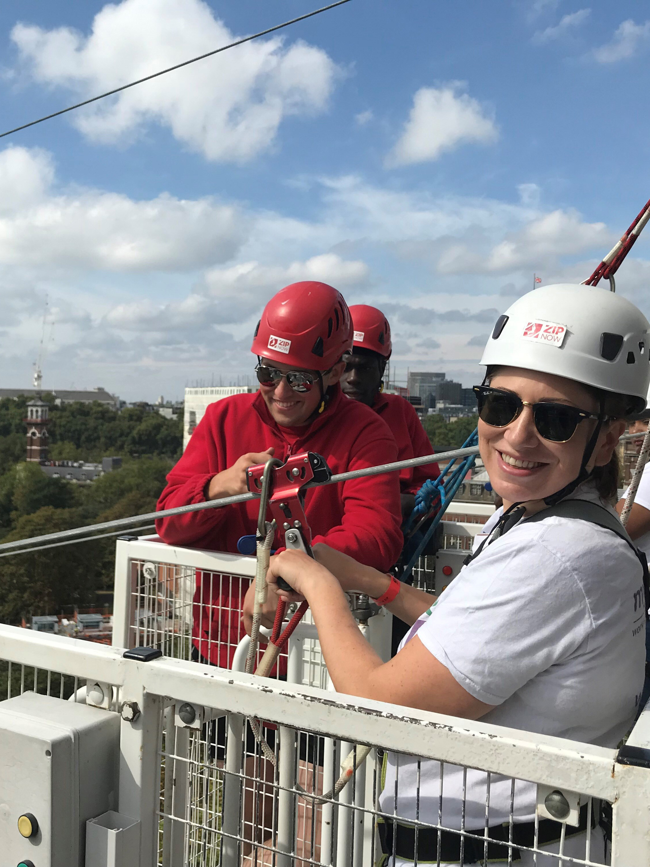 Laura smiling at the camera at the top of the Zip Wire, getting ready to jump