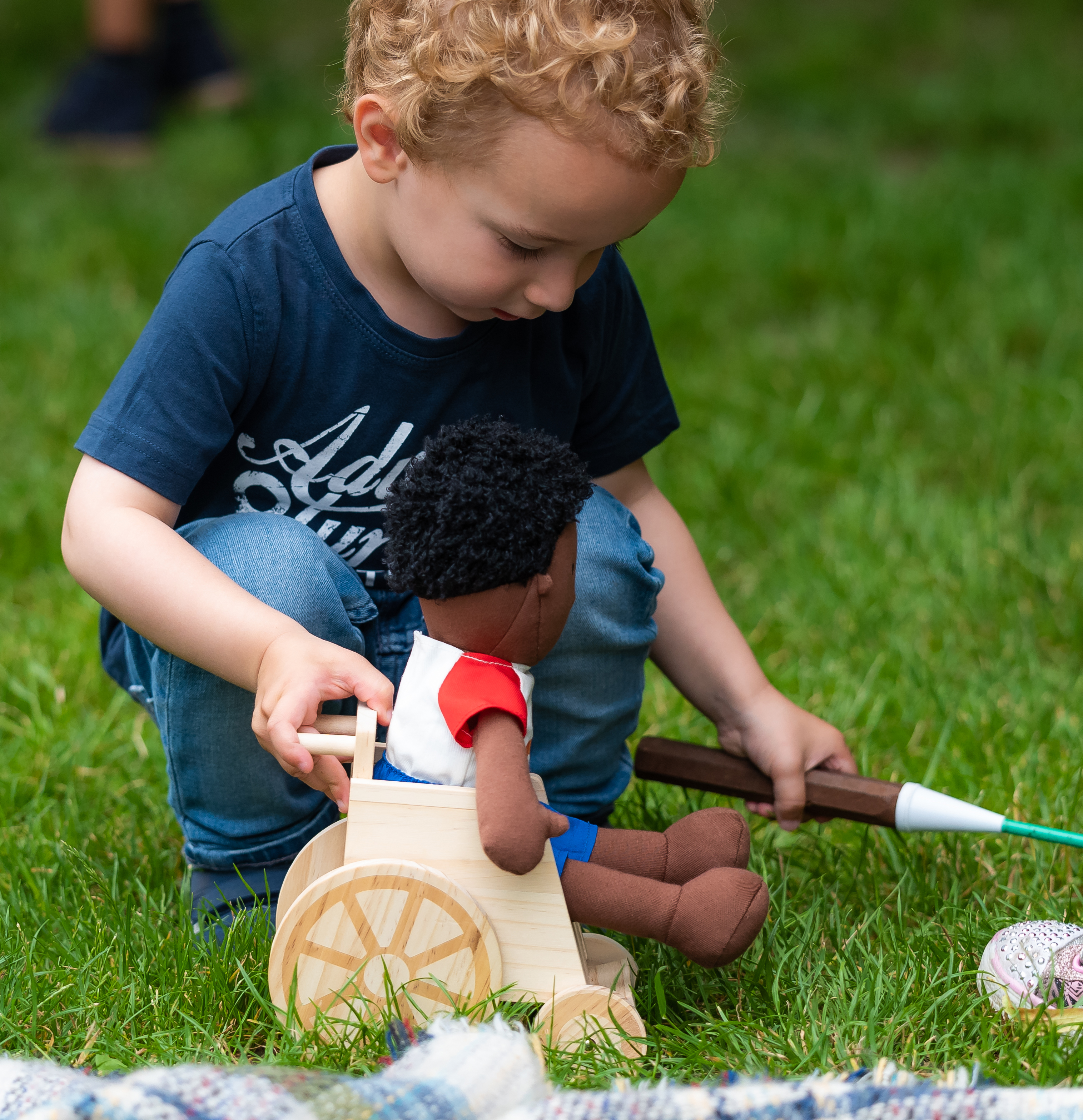 little boy playing with a doll in a wheelchair