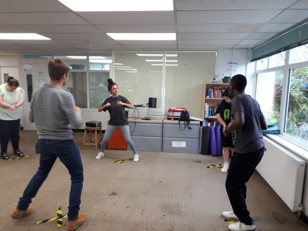 A group of young people do exercise while socially distanced