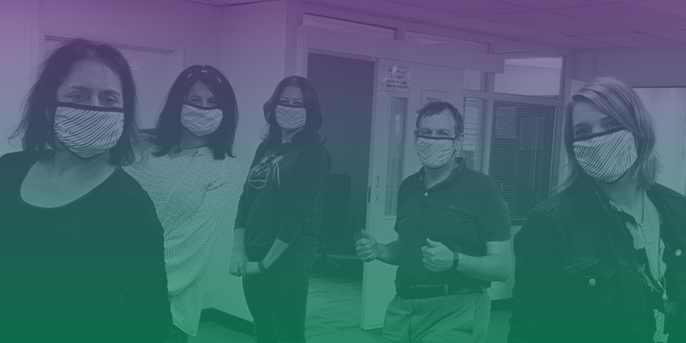 Group of AFK staff in masks with a green to purple filter over the image