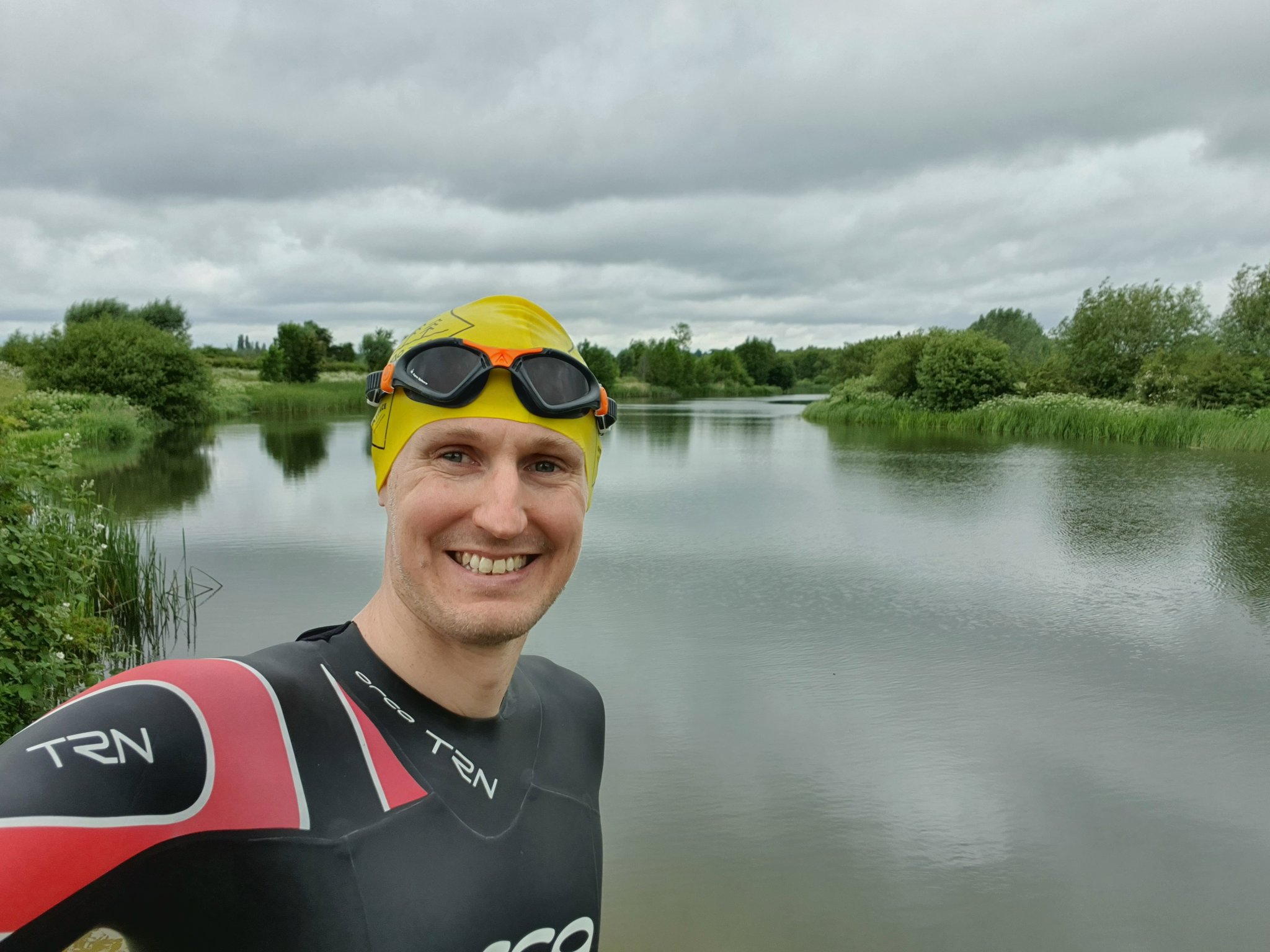 Toy industry member Martin Rowe in a wetsuit and swim cap by a river