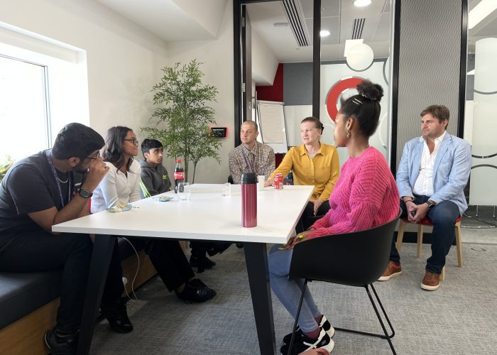 group of young people sat around an table in a professional setting