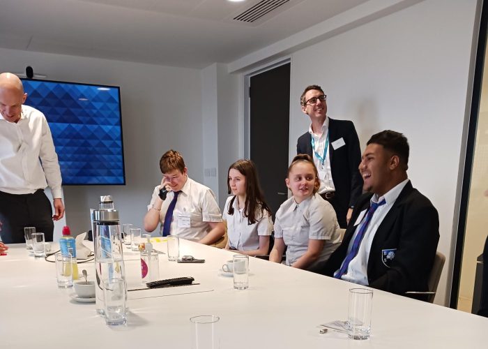 group chatting in office setting around a table