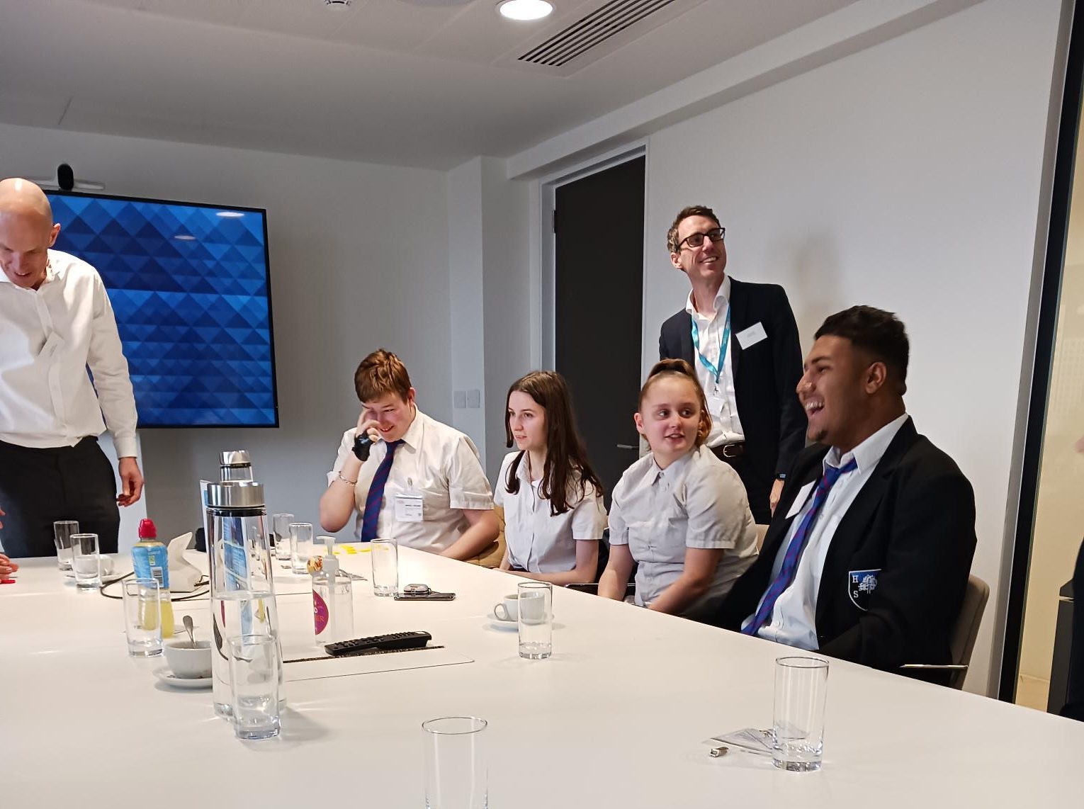 group chatting in office setting around a table