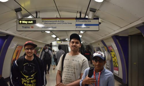 three young men navigating the london underground