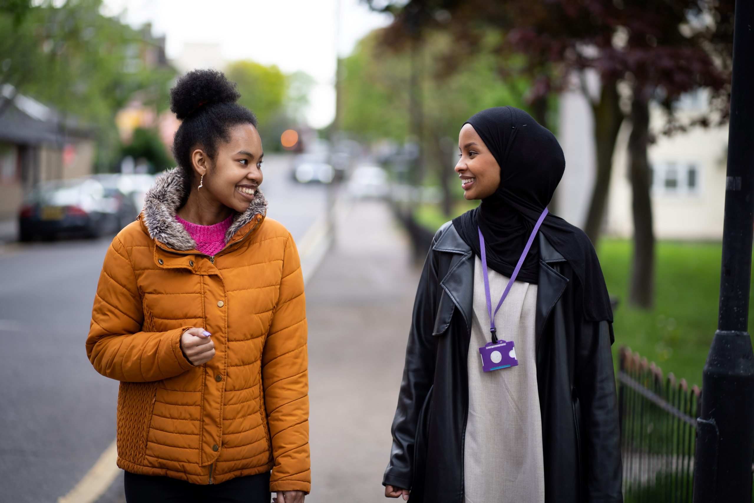 two young women walking down the street smiling