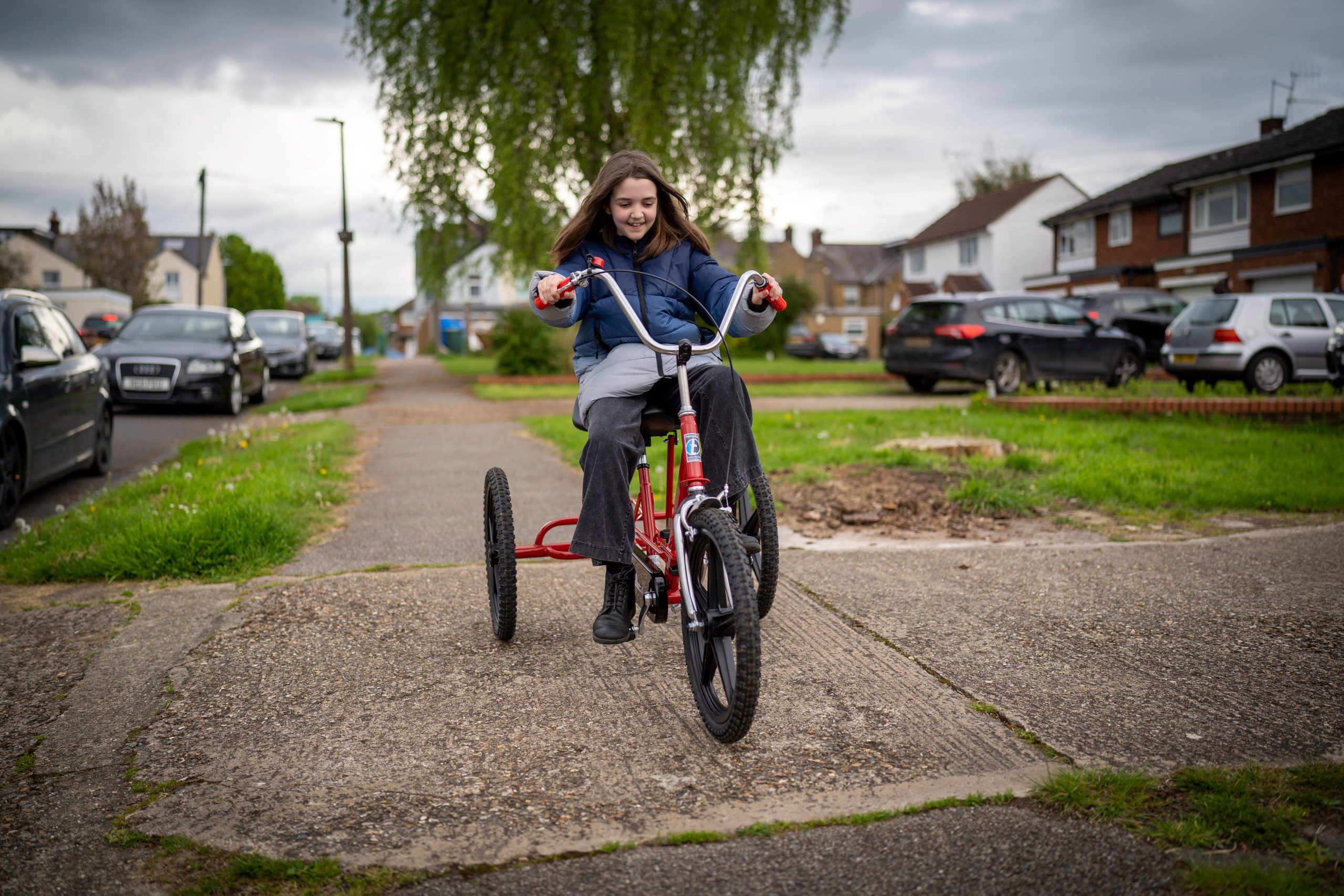 girl riding trike on pavement