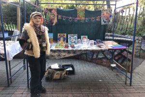 girl standing at market stall selling artwork